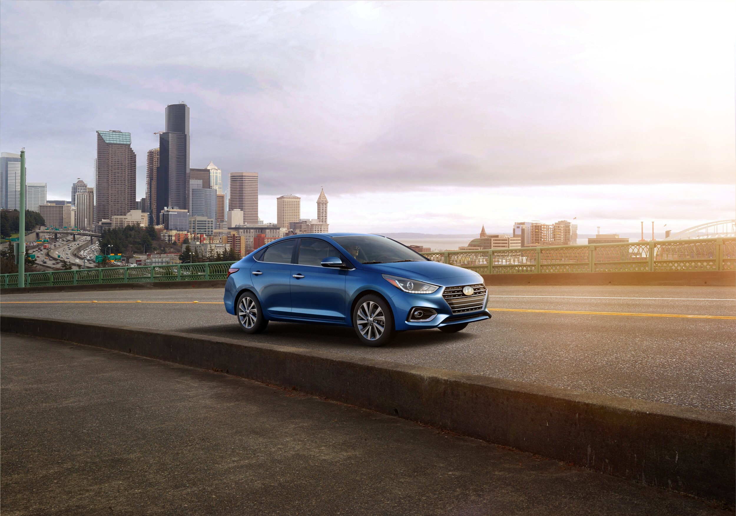Jack Giambalvo Hyundai is a Hyundai Dealership in York near Lancaster, PA | 2020 Hyundai Accent driving on road with city skyline in the distance