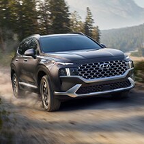 Model Features of the 2022 Hyundai Santa Fe at Jack Giambalvo Hyundai | Santa Fe driving fast on dirt path
