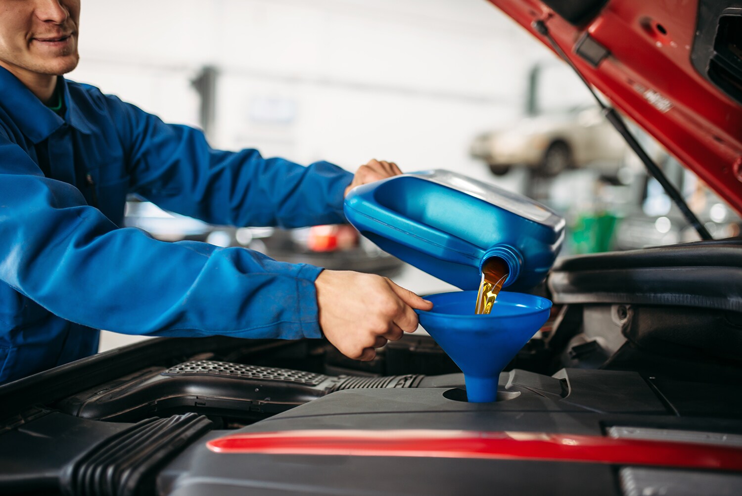 Difference between synthetic oil & conventional oil at Stetler Dodge, Chrysler, Jeep, and Ram | Service technician changing engine oil