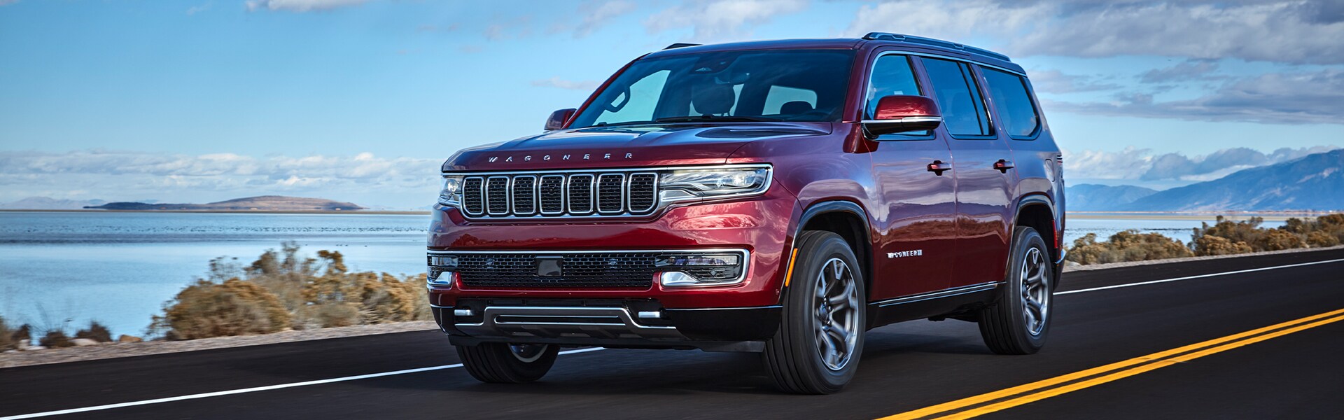 Performance features of the 2022 Wagoneer at Stetler Dodge, Chrysler, Jeep, and Ram of York | The new 2022 Jeep Wagoneer driving alongisde a lake in the desert