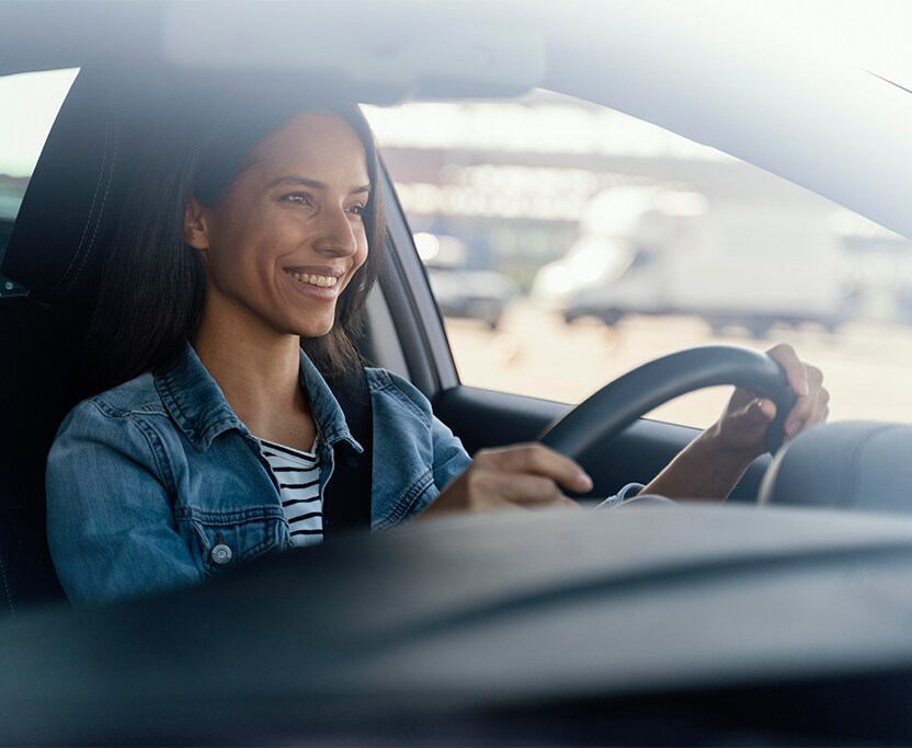 Extend the Life of Your Vehicle at Jack Giambalvo Mazda in York, PA | Woman smiling while having both hands on the steering wheel
