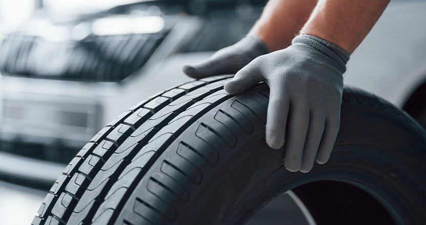 Extend the Life of Your Vehicle at Jack Giambalvo Mazda in York, PA | Person with grey gloves is rolling new car tires