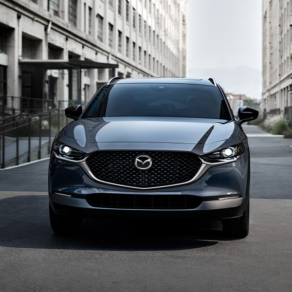 The 2022 Mazda CX-5 vs. The 2022 Mazda CX-30 at Jack Giambalvo Mazda | Dark Silver 2022 Mazda CX-30 Driving Through City