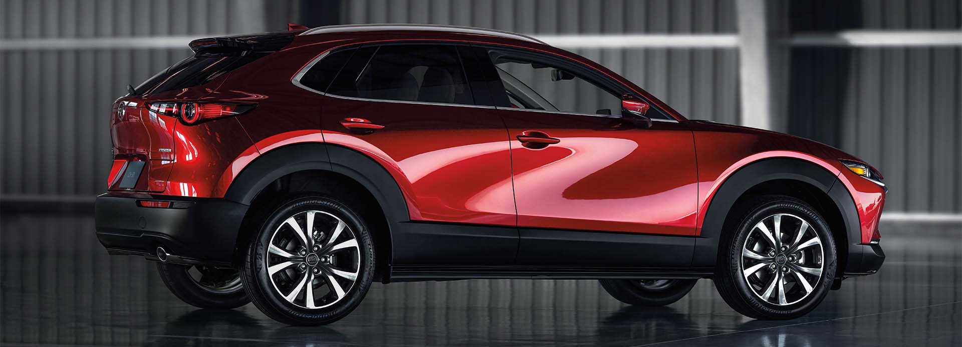 Model Features of the 2021 Mazda CX-30 at Jack Giambalvo Mazda | Red 2021 Mazda CX-30 Side Profile Parked in Garage Studio