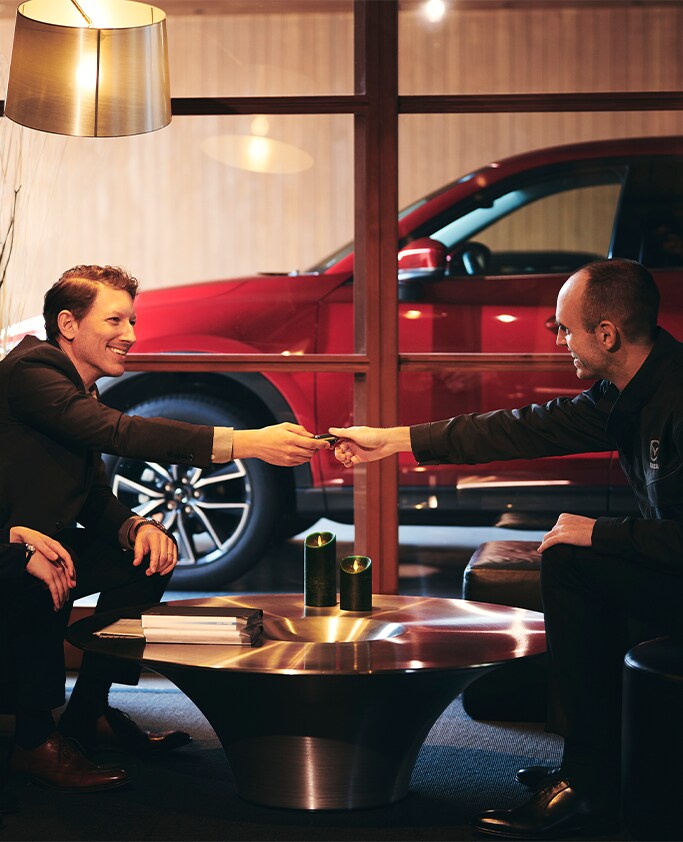 High Cost of Replacing a Car Key | Jack Giambalvo Mazda | Man passing his car keys to a Mazda service associate