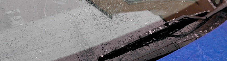 How to prepare your Mazda for the winter season in York, PA at Jack Giambalvo Mazda | Close up of windshield wipers on top of front windshield wipers for blue car