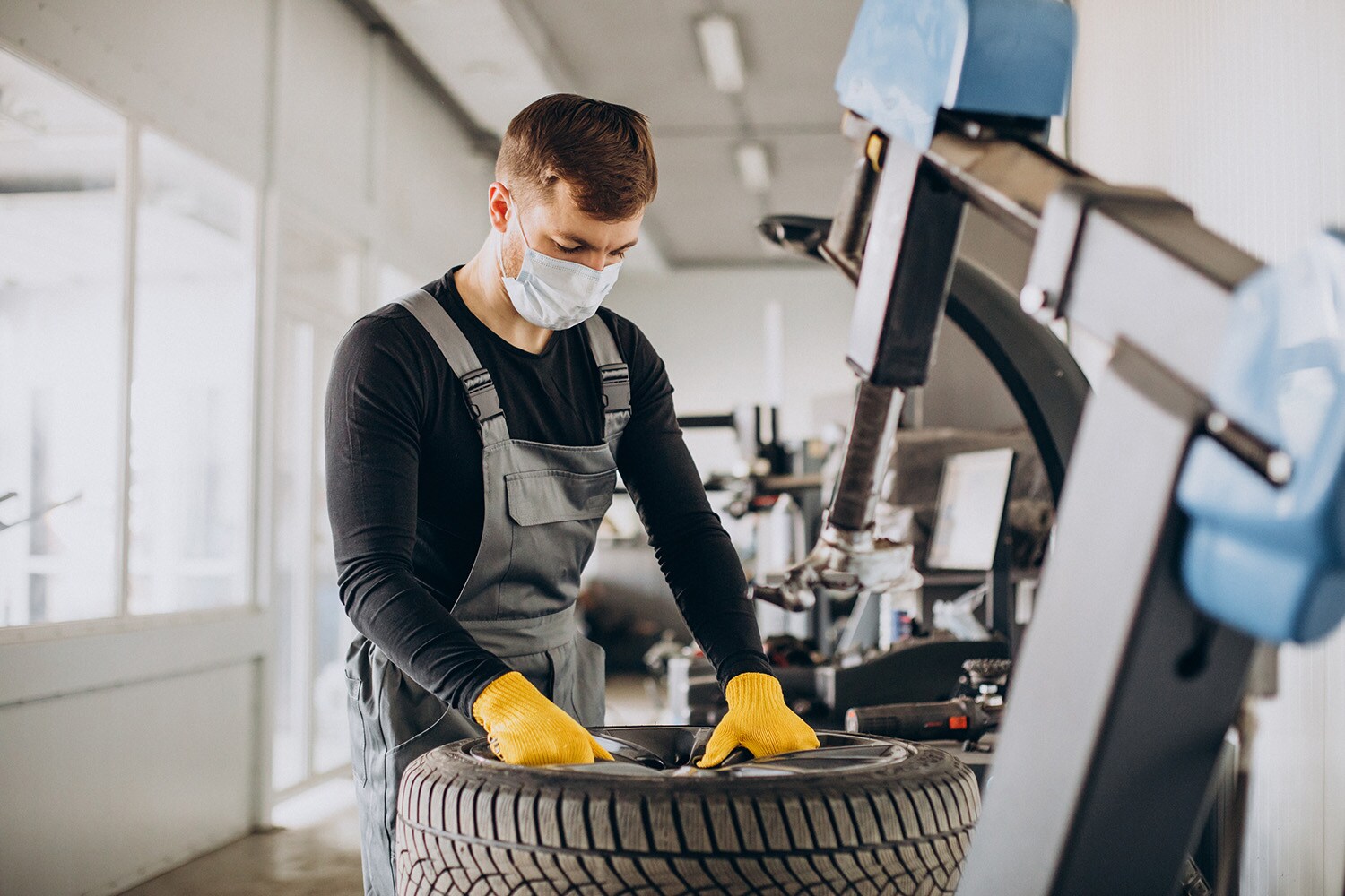 What is a Tire Rotation? at Jack Giambalvo Mazda | Mazda service technician rotating tires for a customer