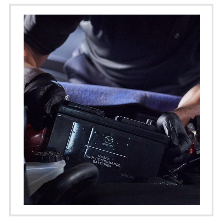 Everything You Need to Know about Your Car Battery at Jack Giambalvo Mazda | Mechanic with black gloves is installing new car battery