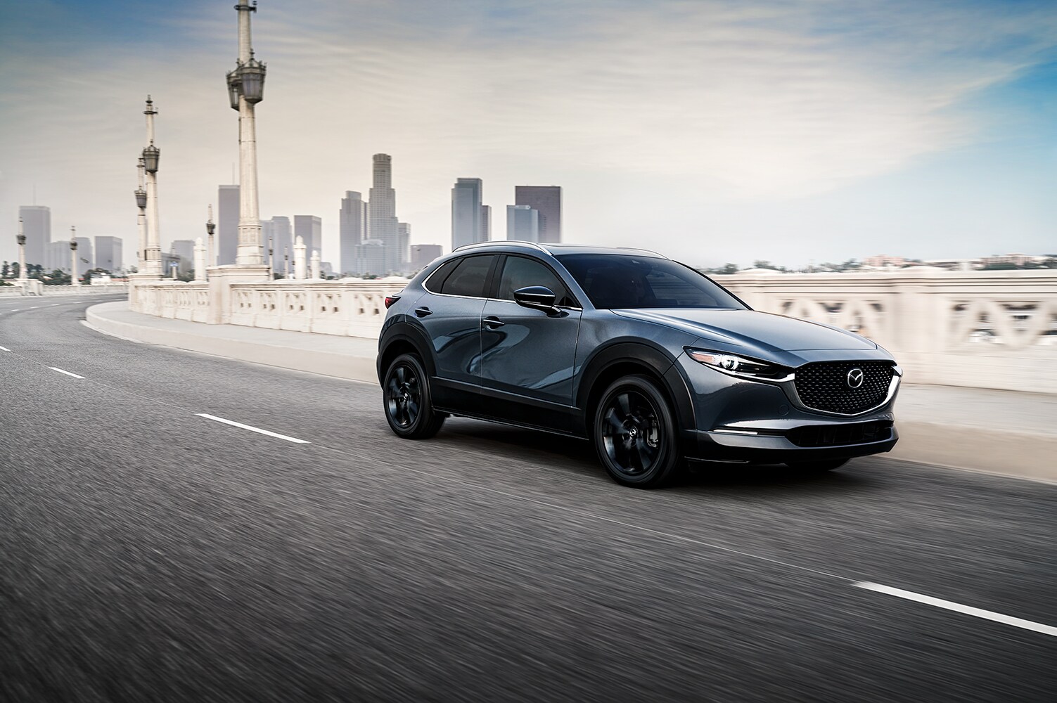 Compare the 2021 Mazda CX-30 vs. the 2022 Honda HR-V at Jack Giambalvo Mazda | 2021 Mazda CX-30 driving on a bridge