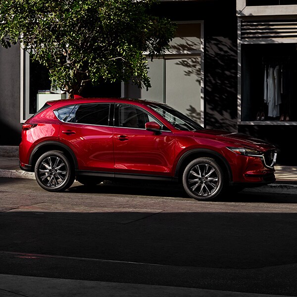 The 2022 Mazda CX-5 vs. The 2022 Mazda CX-30 at Jack Giambalvo Mazda | Red 2022 Mazda CX-5 Street Parked in City