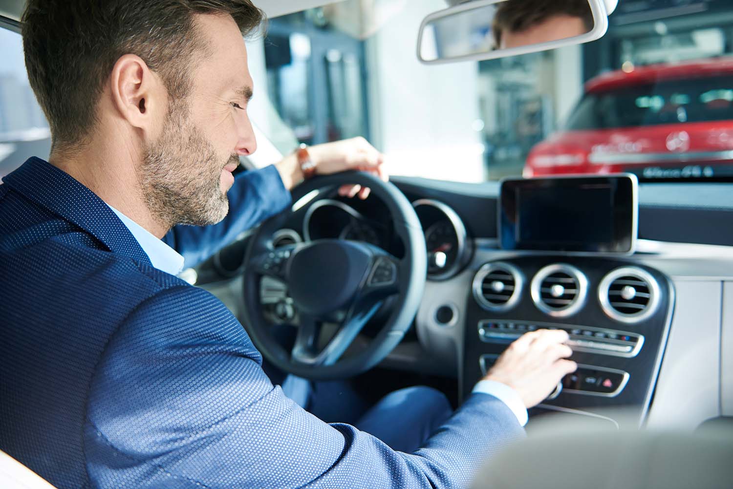 Things to Check When Buying a Used Car | Jack Giambalvo Mazda in York, PA | Customer sitting in vehicle and testing out the buttons to see if all the features work