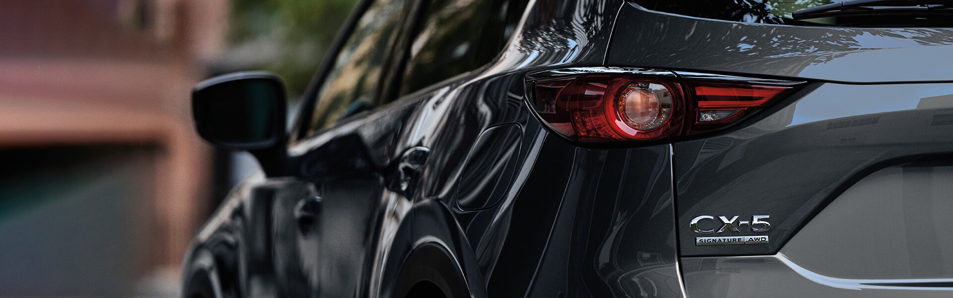 Jack Giambalvo Mazda is a Car Dealership in Dillsburg, PA | A selective focus shot of a black Mazda's driver side door and mirror
