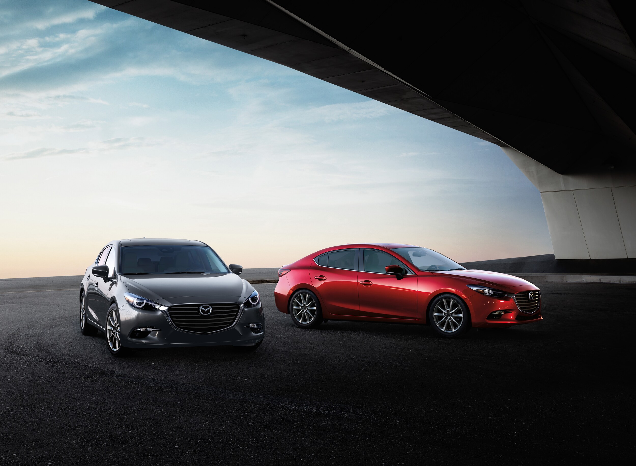 Jack Giambalvo Mazda is a Car Dealership in Red Lion, PA | Two 2020 Mazda3 sedans parked under a bridge