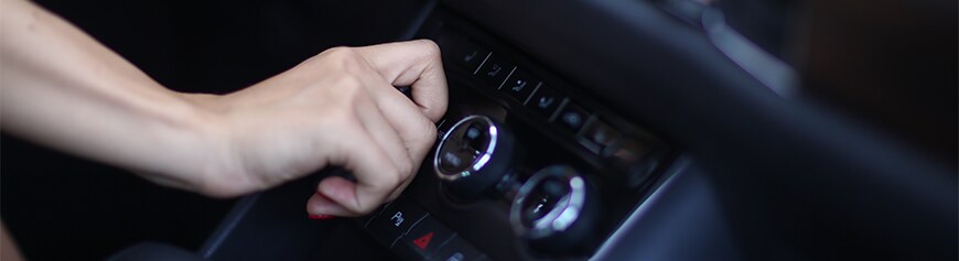 How to prepare your Mazda for the winter season in York, PA at Jack Giambalvo Mazda | Person turning the temperature knob to warm up the car