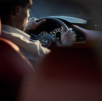 The 2021 Mazda3 vs. The 2021 Mazda6 at Jack Giambalvo Mazda | Close-up of driver driving Mazda3