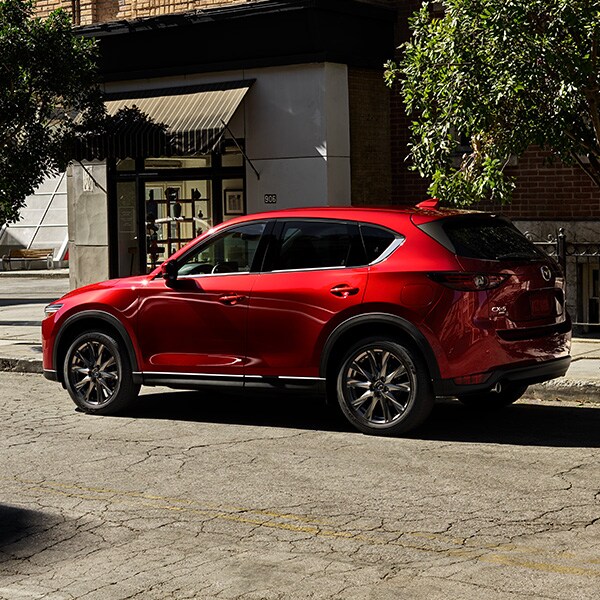 The 2022 Mazda CX-5 vs. The 2022 Mazda CX-30 at Jack Giambalvo Mazda | Red 2022 Mazda CX-5 Street Parked in City