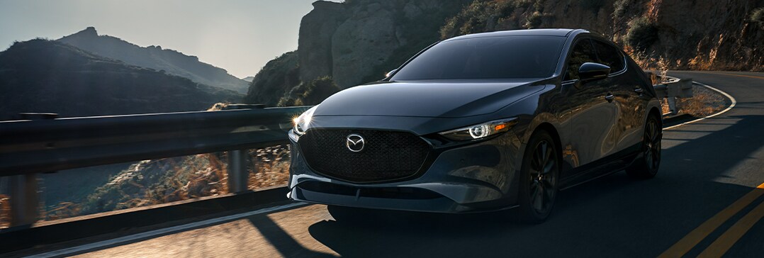 Model Features of the 2021 Mazda3 at Jack Giambalvo Mazda | Mazda 3 driving next to cliff