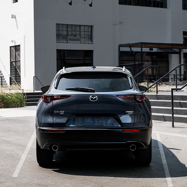 The 2022 Mazda CX-5 vs. The 2022 Mazda CX-30 at Jack Giambalvo Mazda | Rear View of Dark Silver 2022 Mazda CX-30 Parked in Parking Spot