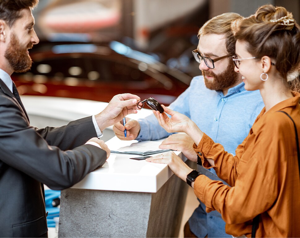 Top Ten FAQs For New Car Buyers in York, PA | Sales person handing over new car keys to couple