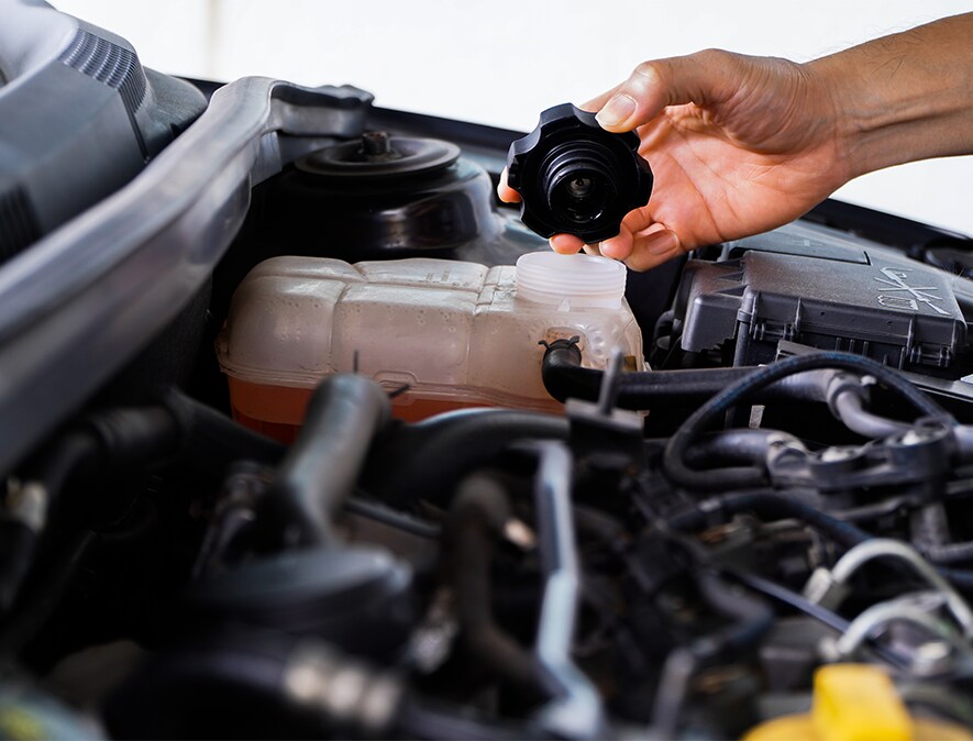How to Get Your Car Summer Ready at Jack Giambalvo Mazda in York, PA | Person's hand holding a lid to coolant reservoir