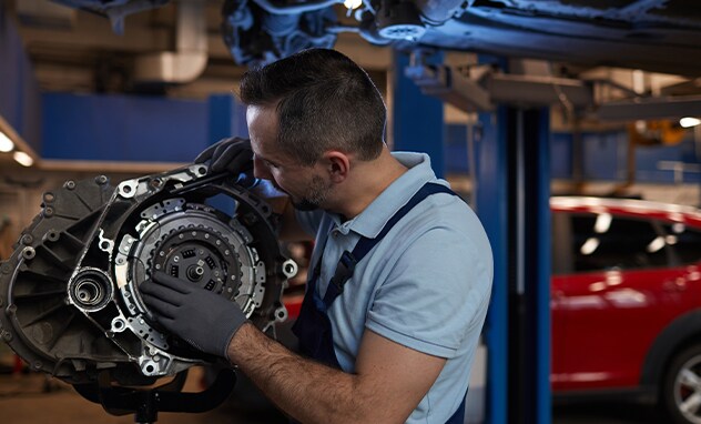 Jack Giambalvo Mazda is a Car Dealership in Dillsburg, PA | An Auto mechanic examining the torque converter on a transmission