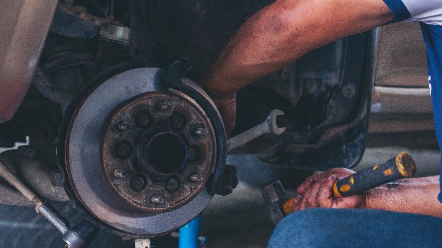 An engineer working on a vehicle's wheel.