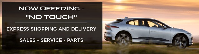 NOW OFFERING NO TOUCH EXPRESS SHOPPING AND DELIVERY. SALES SERVICE AND PARTS. SILVER JAGUAR I-PACE DRIVING DOWN ROAD AT SUNSET.