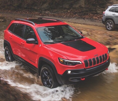 2019 Jeep Cherokee A red 2019 Jeep Cherokee offroading in a river