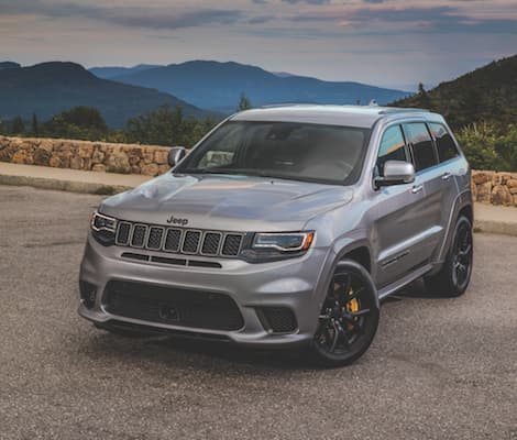 2019 Jeep Grand Cherokee A silver 2019 Jeep Grand Cherokee parked at a mountain overlook