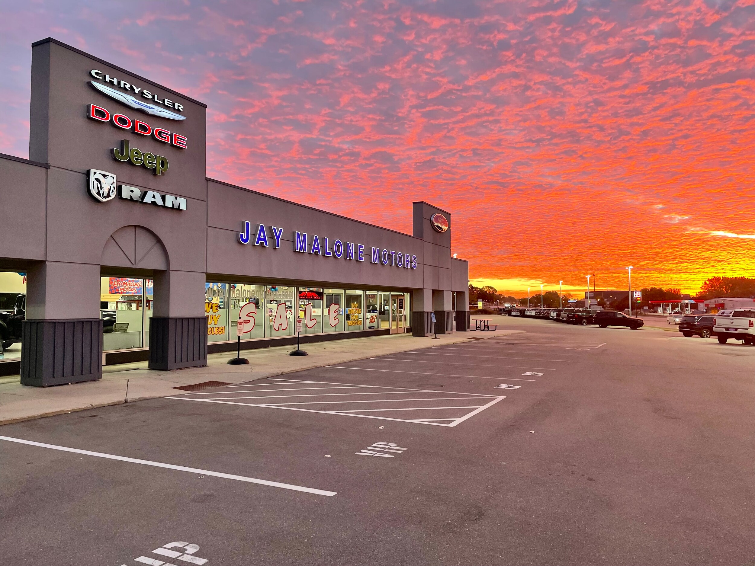 Jay Malone Motors dealership in Hutchinson MN with rainbow — used cars trucks and SUVs for central Minnesota