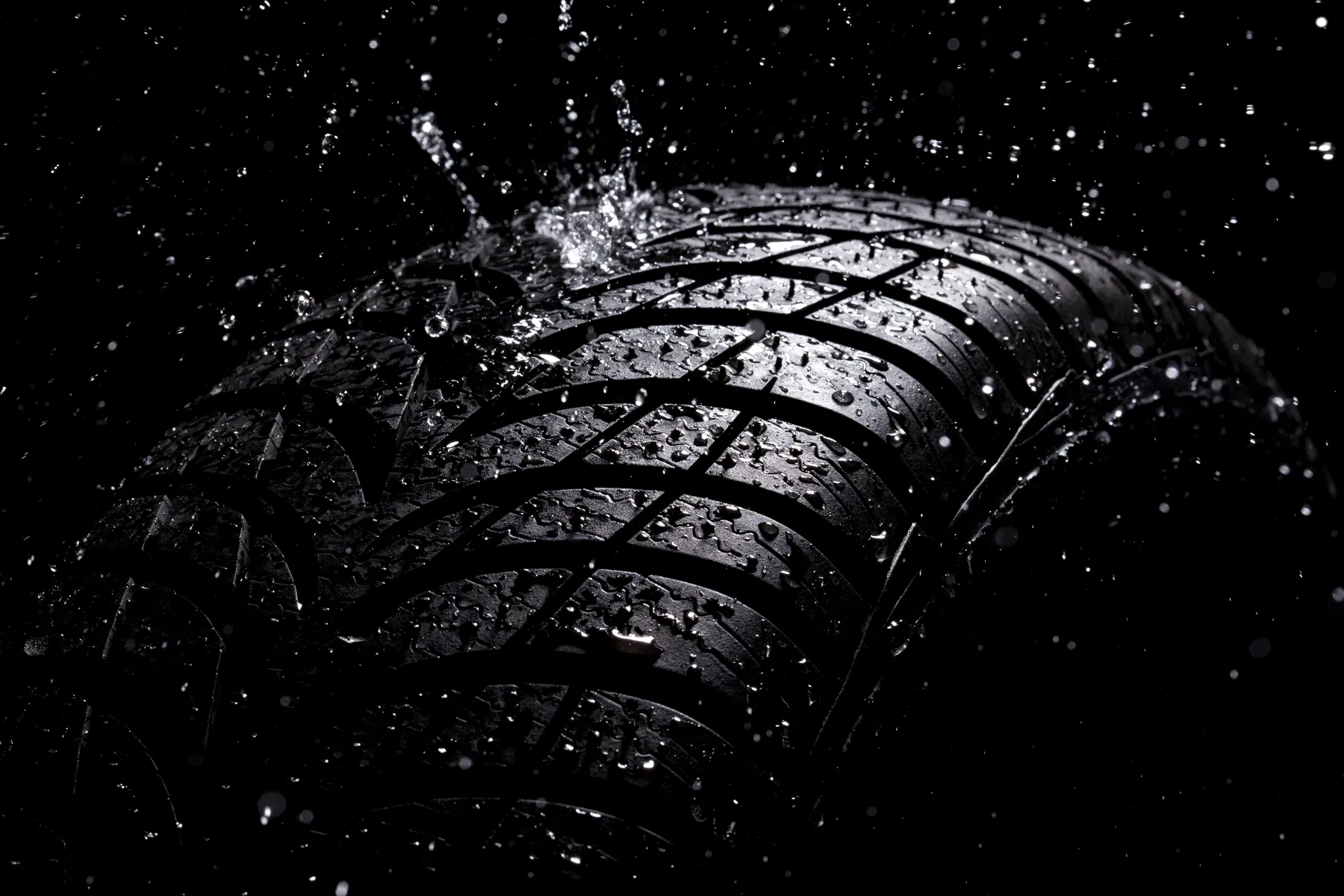 Tread depth defends against desert monsoon runoff Dramatic close-up of tire tread with water splashing over grooves