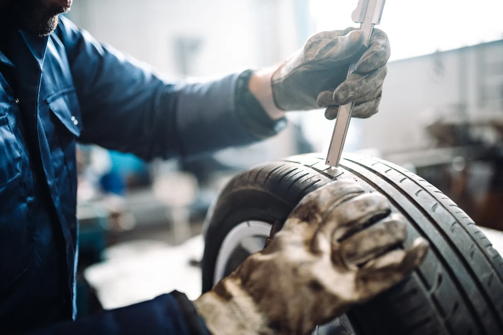 Certified technician measuring Jeep tire tread depth Certified technician measuring tire tread depth with a caliper