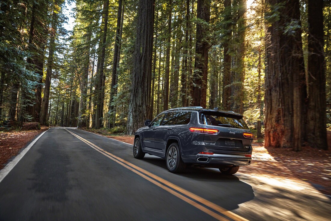 2021-Jeep-GrandCherokeeL-Summit-SUV-L12.png black Grand Cherokee L driving on a forest road