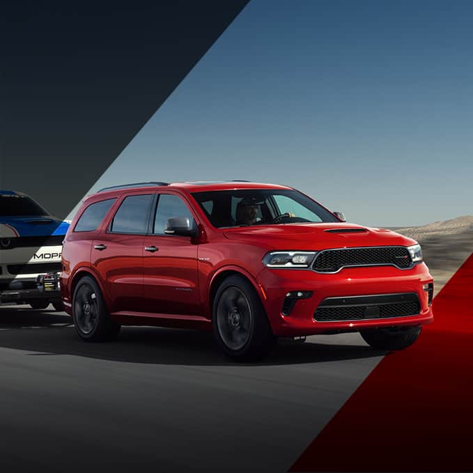 red Dodge Durango on a race track with another close behind
