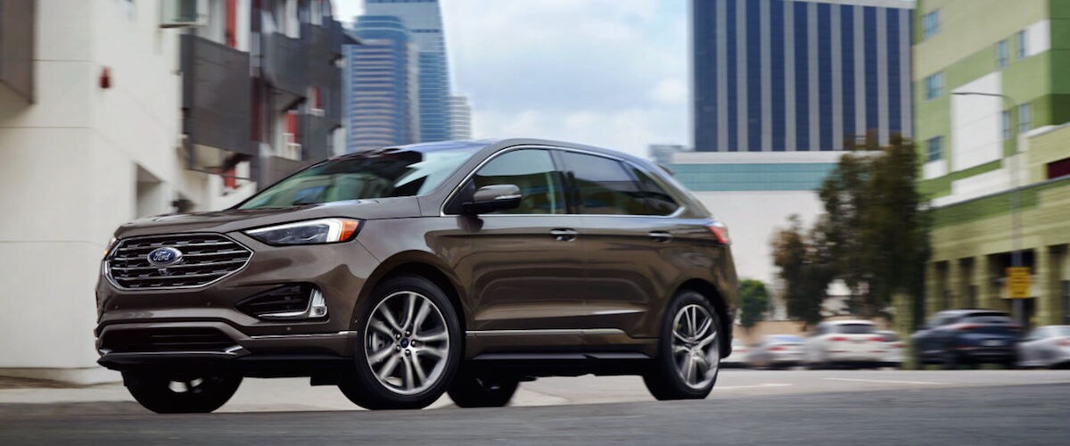 2019 Ford Edge A brown 2019 Ford Edge driving through a city