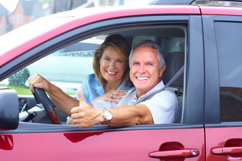 senior couple driving leased car