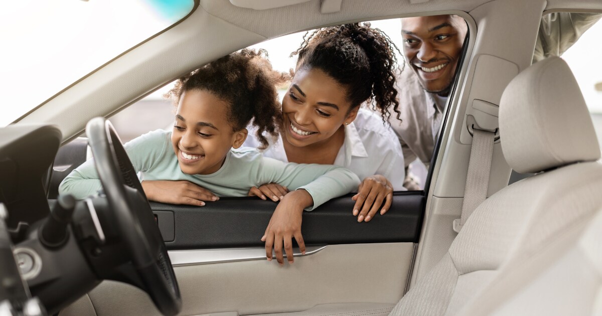 Smiling family looks at the interior of their new vehicle Smiling family looks at the interior of their new vehicle