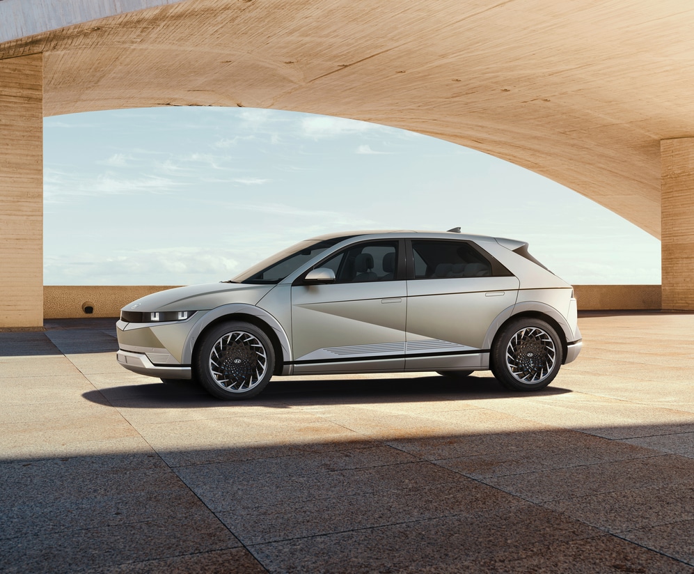 2024-Hyundai-IONIQ5-Limited-SUV-L09.png white Hyundai Ioniq 5 electric SUV parked next to a sandstone archway
