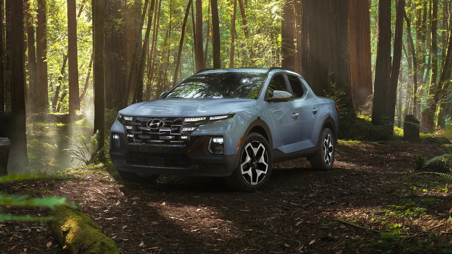 light blue Hyundai Santa Cruz parked in the woods