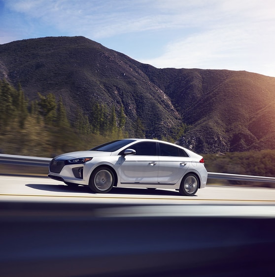 2017-Hyundai-Ioniq-Limited-Sedan-L07.png white Hyundai Ioniq driving on the freeway through the Santa Clarita hills