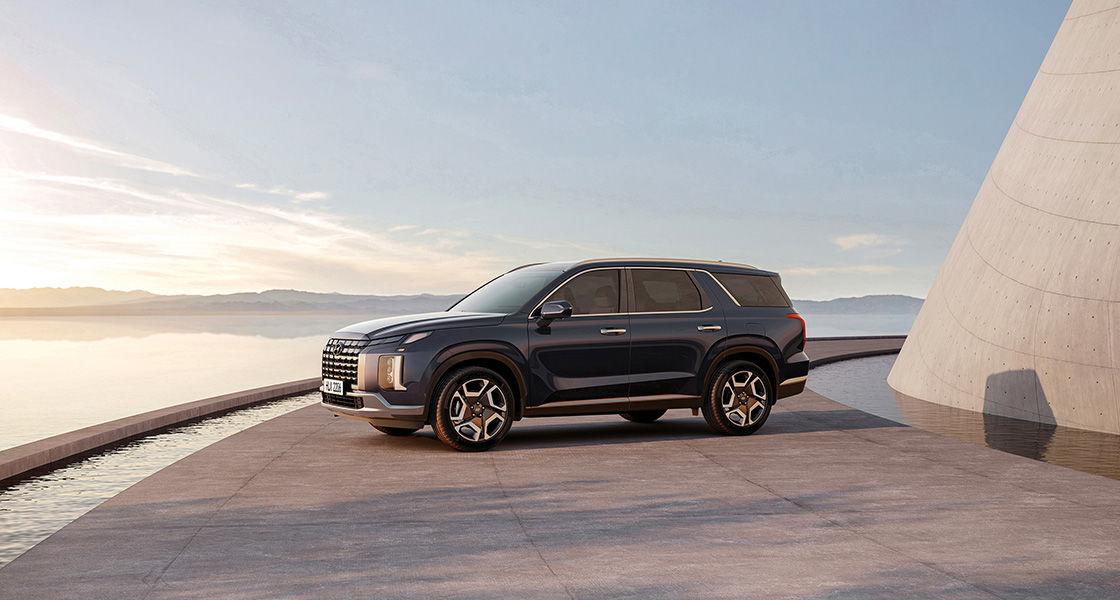 Hyundai Palisade parked on sandstone tile with a stylized sandstone building next to it