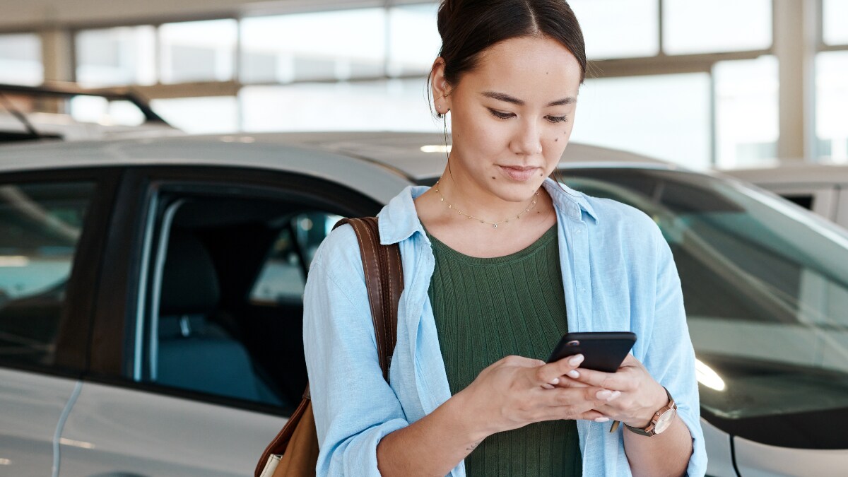 Young woman browsing our used inventory on her phone Young woman browsing our used inventory on her phone