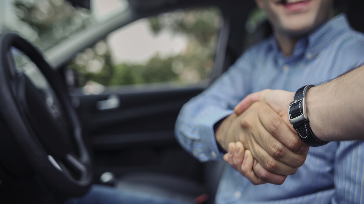Man shaking hands from within his new Hyundai vehicle Man shaking hands from within his new Hyundai vehicle