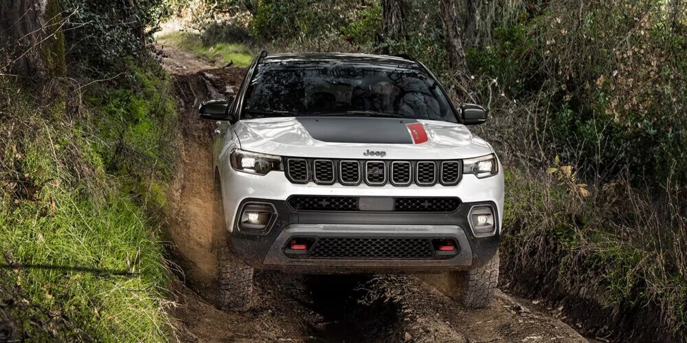 2024 Jeep Compass driving through a forest