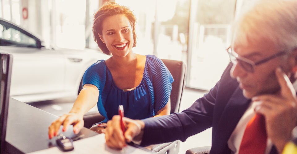 Test drive a new or pre-owned vehicle today! Woman completing a car sale with a businessman