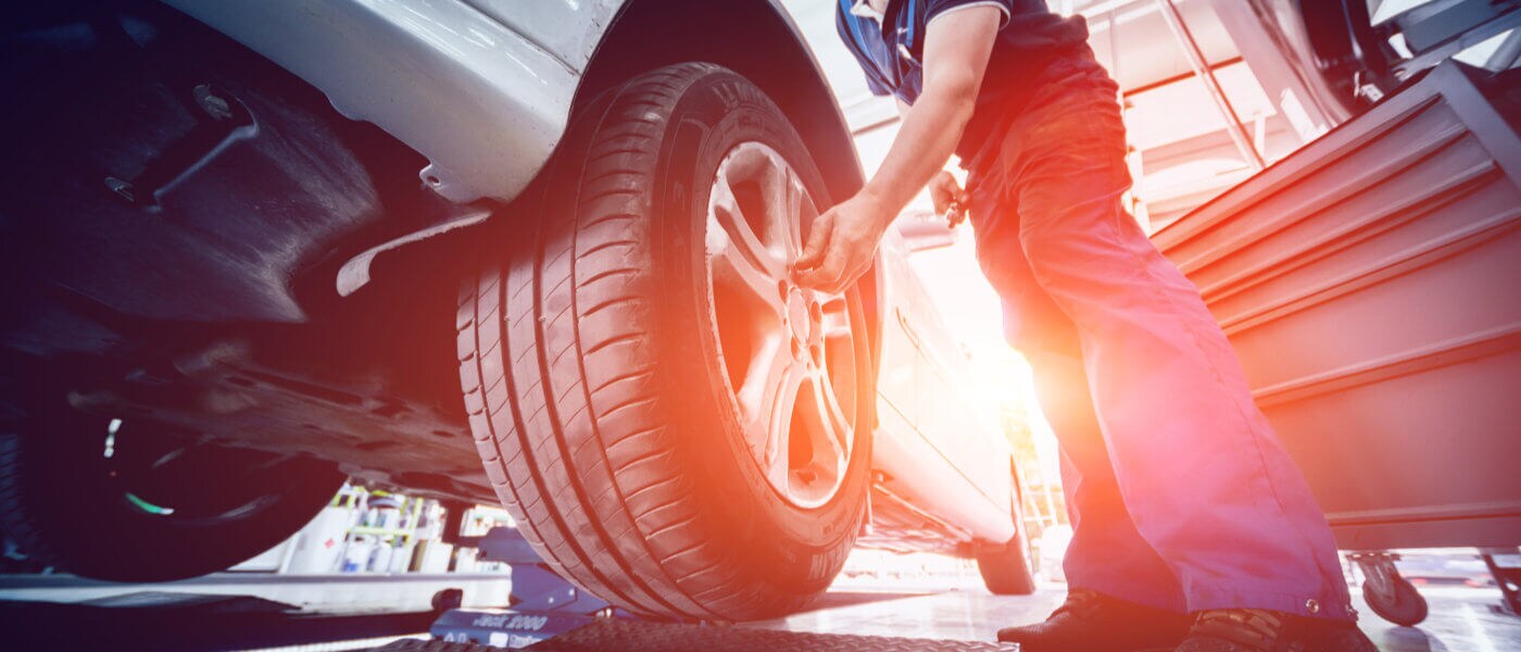 Mechanic reaching for a vehicle's tire