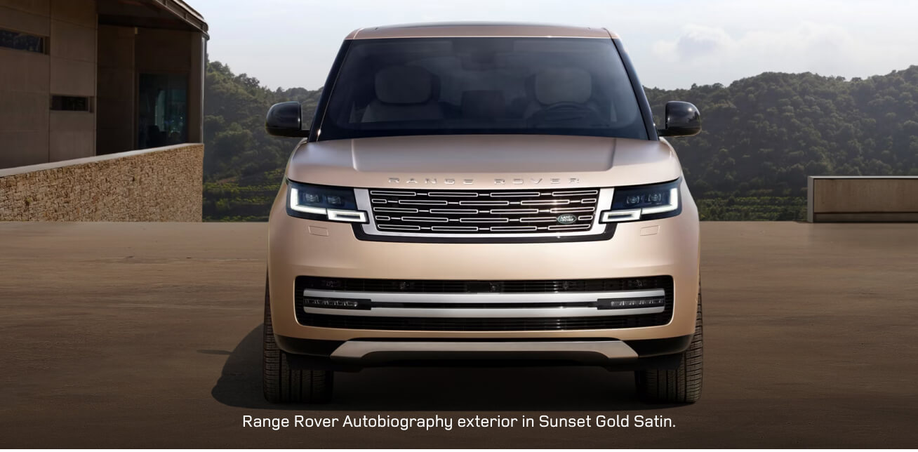 Front view of a Range Rover Autobiography in Sunset Gold Satin parked on a villa driveway.