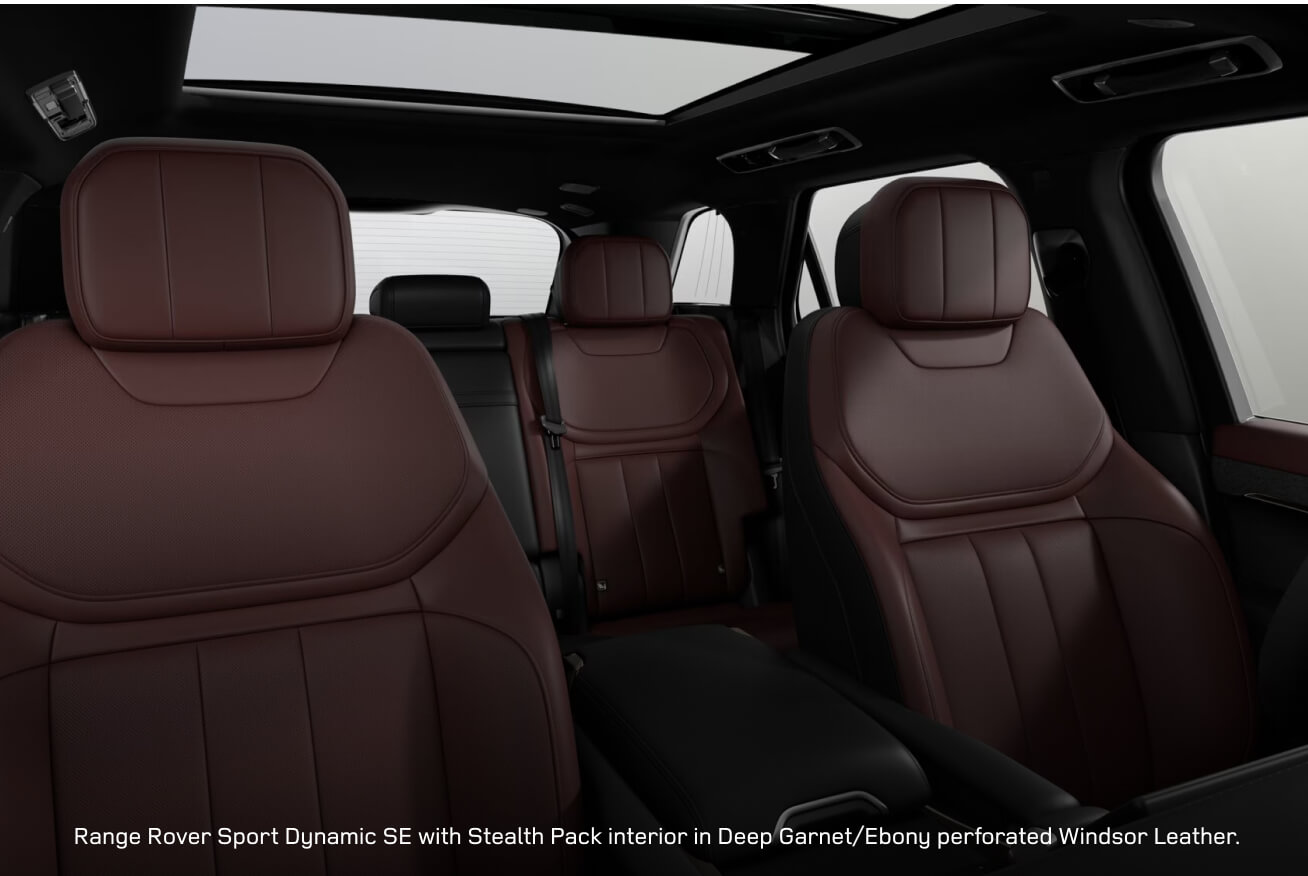 Interior cabin view of a Range Rover Sport Dynamic SE with Stealth Pack showcasing Deep Garnet seats under open roof.