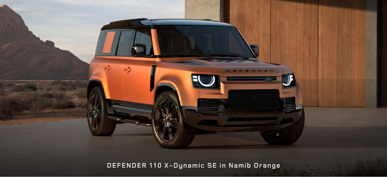 Front three-quarter view of a Land Rover Defender 110 X-Dynamic SE SUV in Namib Orange.