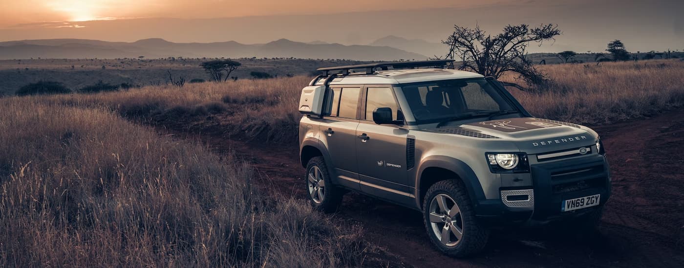 Grey 2026 Land Rover Defender driving off-road.